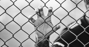 man holding chain-link fence